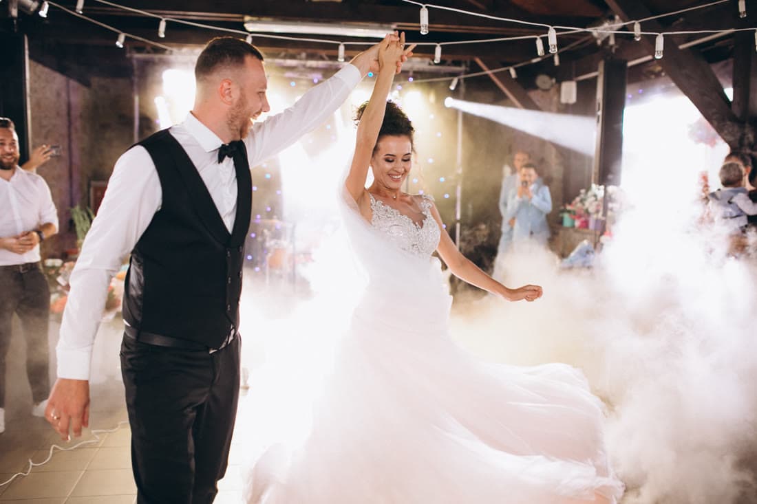 A newly married couple dancing alone on the floor while guests watch